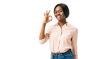 smiling african american woman showing ok gesture isolated on white