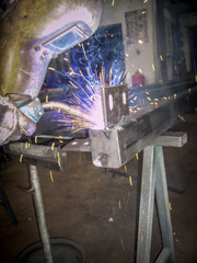 Metallbauer schweißt Lasche an ein großes Stahlrohr