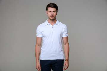 Image of concentrated man wearing basic t-shirt looking at camera