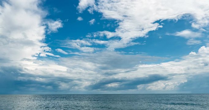 4k time lapse of the sea and blue sky, white clouds evolve and change shape, dynamic weather, beautiful seascape