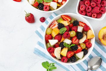 Fruit and berry salad in white bowl