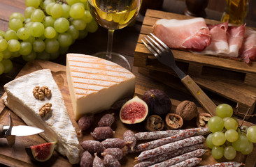 cheese,wine,sausage, ham on rustic wooden background