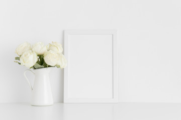 White frame mockup with a bouquet of white roses in a vase on a white table.Portrait orientation.