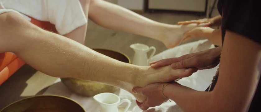 a masseuse giving a foot massage to a man with the aid of a golden bowl - Eine Masseuse gibt einem Mann eine Fu&szlig;massage mithilfe einer goldenen Sch&uuml;ssel