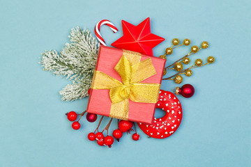 Red and blue Christmas composition. Red gift, holly berries, stars, glass baubles and green fir...