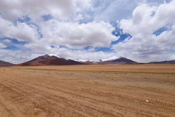 Landscape of the Bolivian highlands. Desert landscape of the Andean plateau of Bolivia with the peaks of the snow-capped volcanoes of the Andes