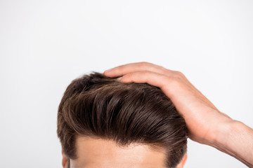 Cropped close-up photo of macho fix his haircut after anti dandruff therapy isolated over white...