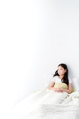 Obraz na płótnie Canvas Young girl lay on a white bed