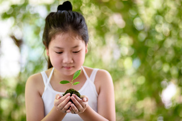 Young girl carry a young seedling