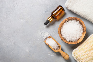 Sea salt and cosmetic oil on gray stone background.