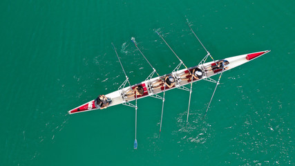 Aerial drone photo of team of Athletes rowing in sport canoe in tropical exotic lake