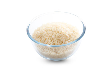 Bol de cristal  de arroz crudo sobre fondo blanco, vista cenital. Glass bowl of raw rice on white background, overhead view.