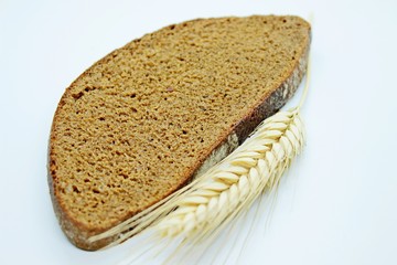 A piece of bread and rye spike located on a white background