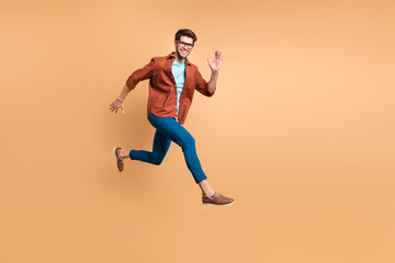 Full length body size view of his he nice attractive cheerful cheery glad active successful guy leader jumping in air running fast hurry-up meeting isolated over beige color pastel background