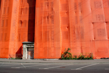 Bright orange textured fabric for the facade shelter of the house during reconstruction and repair....
