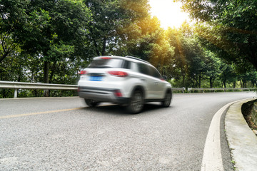 Fototapeta na wymiar Cars pass through the forest from asphalt road