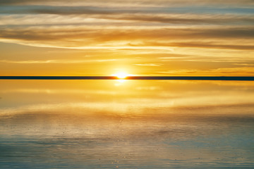 Scenic magic golden and blue sunset in bolivian salar Uyuni