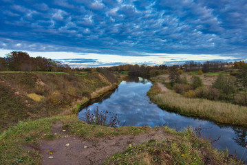 Fototapeta na wymiar Dramatic sky reflected in a tranquil winding river