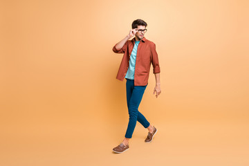 Fototapeta na wymiar Full length body size view of his he nice attractive fashionable calm brunet guy business shark expert specialist touching specs walking isolated over beige color pastel background