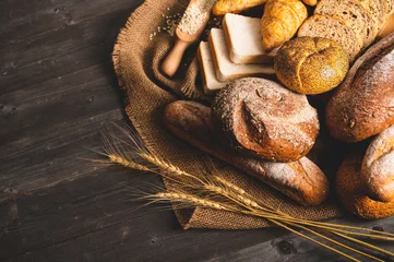 Tuinposter Different kinds of bread with nutrition whole grains on wooden background. Food and bakery in kitchen concept. Delicious breakfast gouemet and meal. Top view angle © Shutter2U