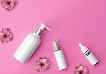 Cosmetics flat lay on pink background. Bottle of lottion, serum and spray.
