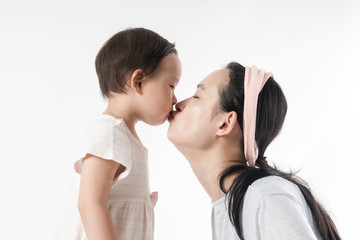 The girl is kissing her mother in the white background