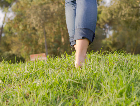 feet on green grass walking. Selective focus