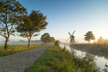Windmill during a foggy, autumn sunrise in the Dutch countryside. Krimstermolen, Zuidwolde.