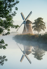 Windmühle während eines nebligen Herbstsonnenaufgangs in der niederländischen Landschaft. Krimstermolen, Zuidwolde.