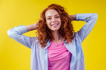 happy young redhaired ginger woman with curly hairstyle pretty face wearing cotton pink shirt in...