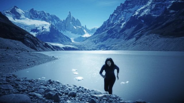 Hispanic woman trail running on the slope of the Fitz roy mountain, Calafate, Argentina. Slow motion