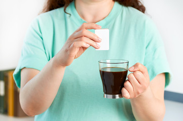 woman hands throwing saccharin into a coffee