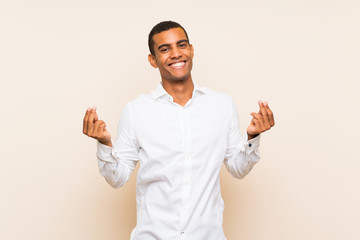 Young handsome brunette man over isolated background making money gesture