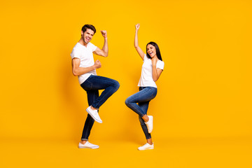 Fototapeta na wymiar Full body photo of pair lady and guy fans supporting favorite football team raising fists wear casual outfit isolated yellow color background