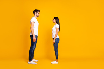 Fototapeta na wymiar Full body profile photo of pair lady and guy looking eyes wait who begin conversation wear casual outfit isolated yellow color background