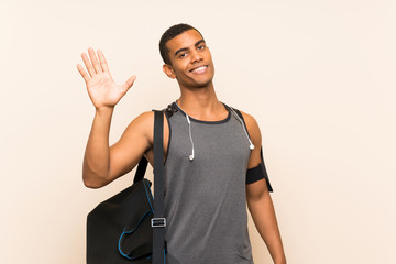 Sport man over isolated background saluting with hand with happy expression © luismolinero