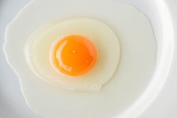 Top view fresh egg yolk on white plat.