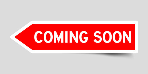 Red color arrow sticker with word coming soon on gray background