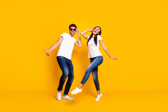 Full body photo of two people dancing at first season theme party wear cool specs and casual clothes isolated yellow color background