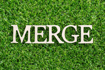 Wood letter in word merge on artificial green grass background