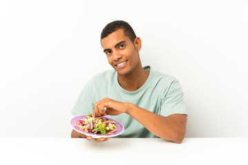 Young handsome man with salad in a table