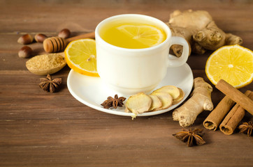 Ginger tea with lemon in a white cup on a wooden table