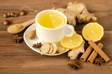 Ginger tea with lemon in a white cup on a wooden table