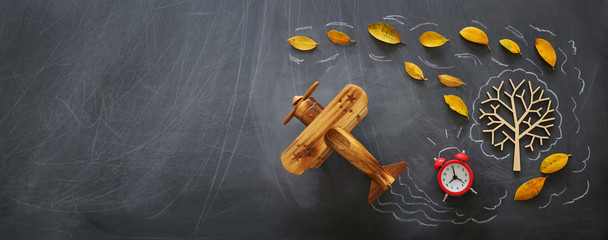 Education concept, banner of vintage airplane on a chalkboard with fall leaves
