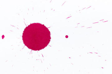 Red ink dot splashed on white paper background