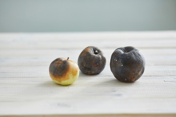 ugly fruit. three rotten apples on the table