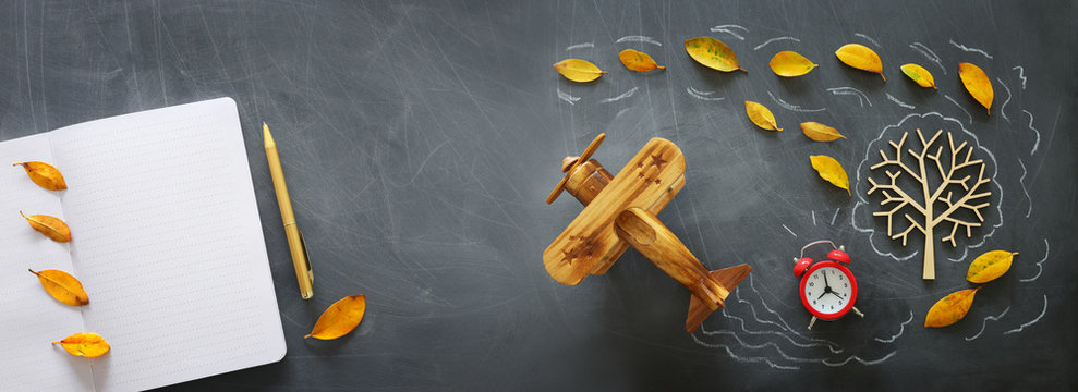 Education concept, banner of vintage airplane on a chalkboard with fall leaves