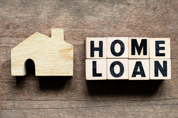 Letter block with word home loan and home model on wood background