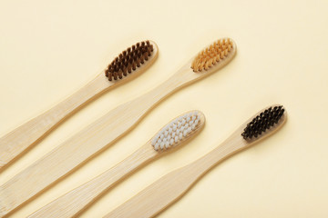 Four eco-friendly bamboo toothbrushes on a yellow background. Zero waste concept, plastic-free, organic, eco-friendly shopping