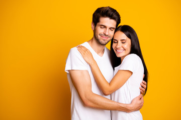 Photo of amazing pair in love holding each other in hands close eyes wear casual white t-shirts isolated yellow color background